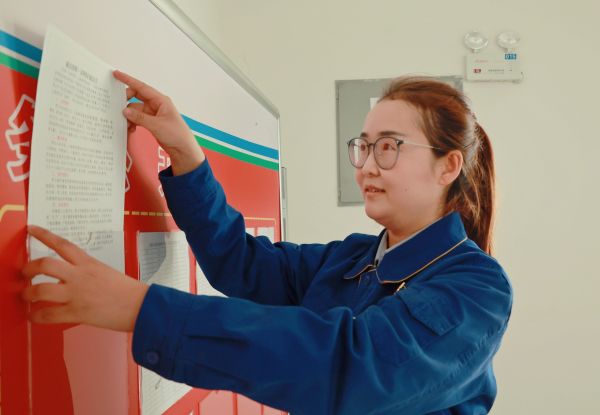 图为_王萍在公告栏更新内容的照片.jpg